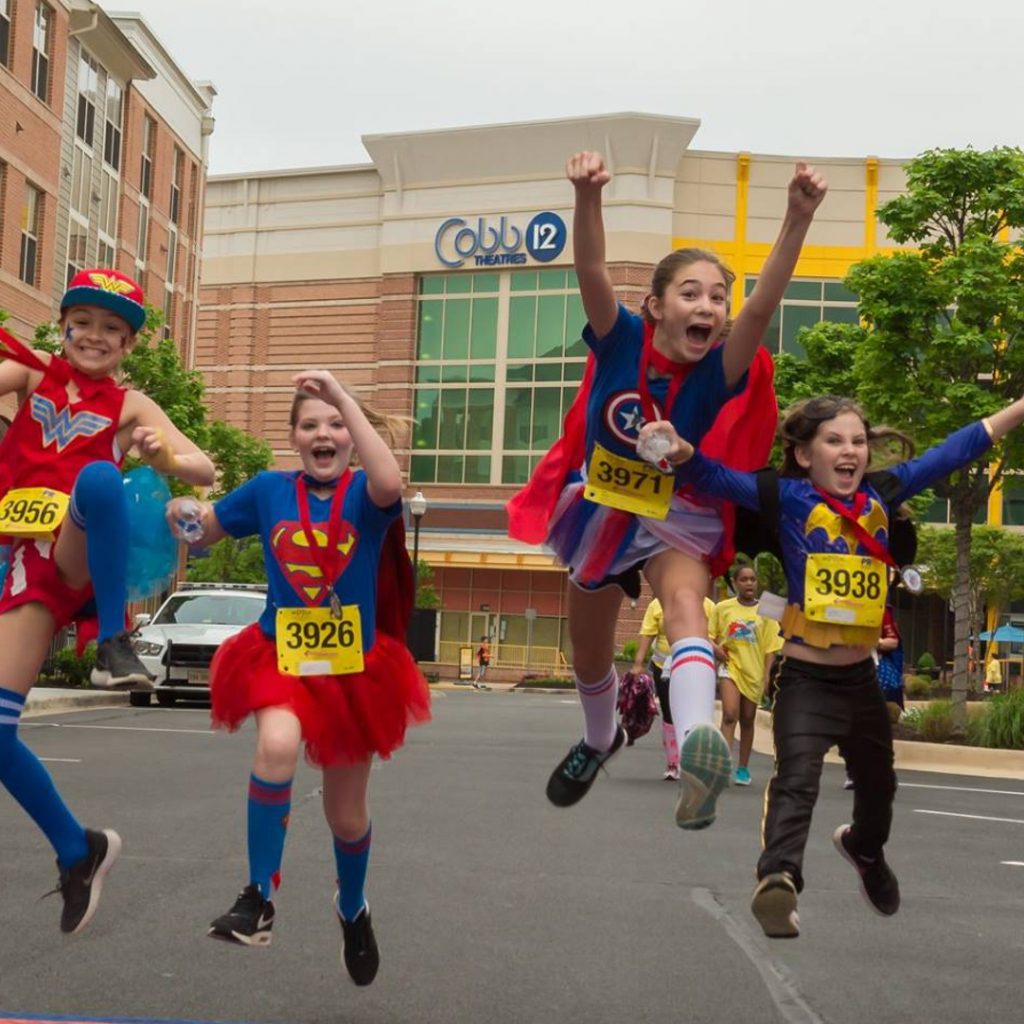 Kids in costumes running and jumping