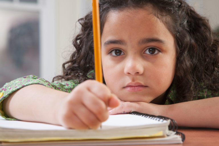 A middle school Hispanic teen girl work on her picture at a free