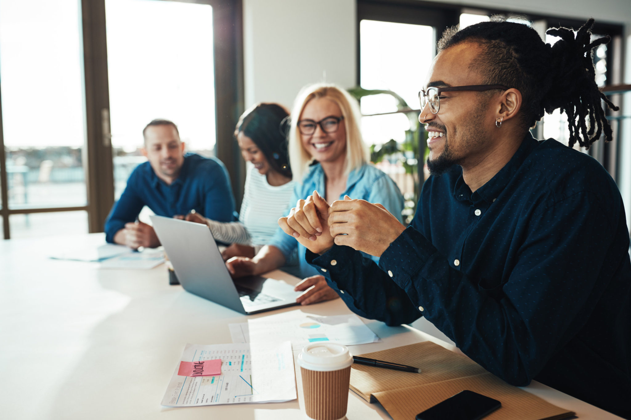 Group of diverse young professionals discussing a project at a table in an office.